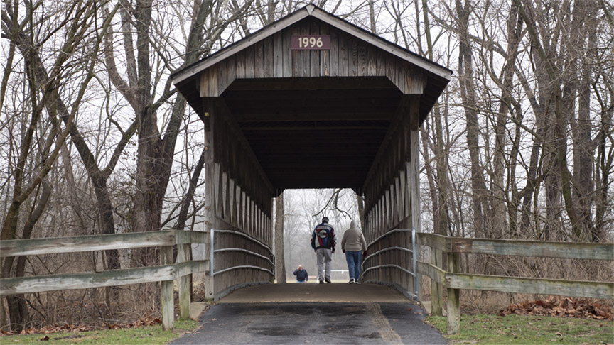 Paved walking trail winding through a wooded park in Mooresville Indiana